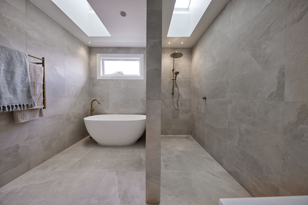 The simple, neutral bathroom features a beige basin, gold handles and lots of storage. Photo: Channel Nine