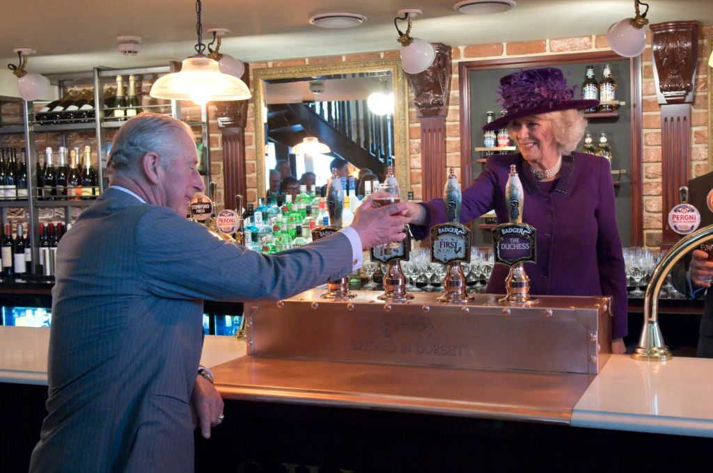 Camilla, the Duchess of Cornwall, serves Prince Charles a pint at one of Poundbury’s two pubs.