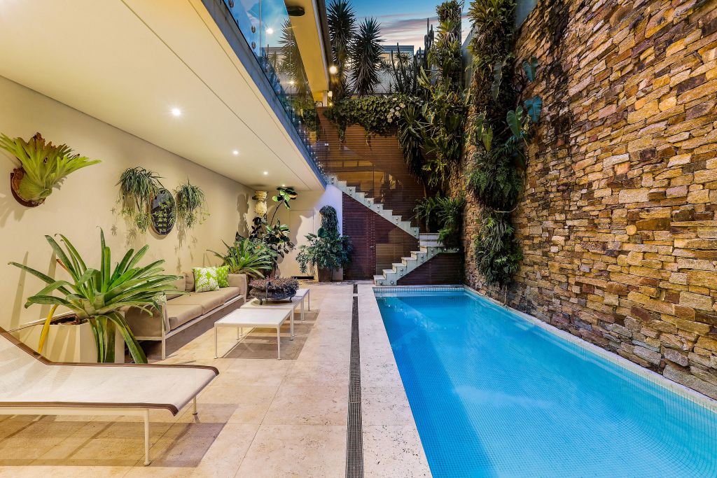 The leafy courtyard is paved in travertine and features a 12-metre, mosaic tiled heated pool. Photo: Supplied