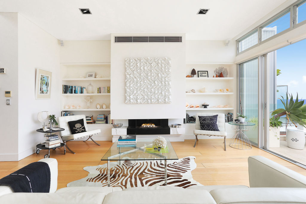 In the living room, the gas fireplace with its marble mantel acts as the room's centrepiece. Photo: Supplied