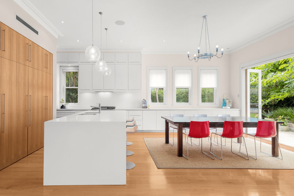 The open-plan kitchen has plenty of storage and a stone-top island bench. Photo: Supplied