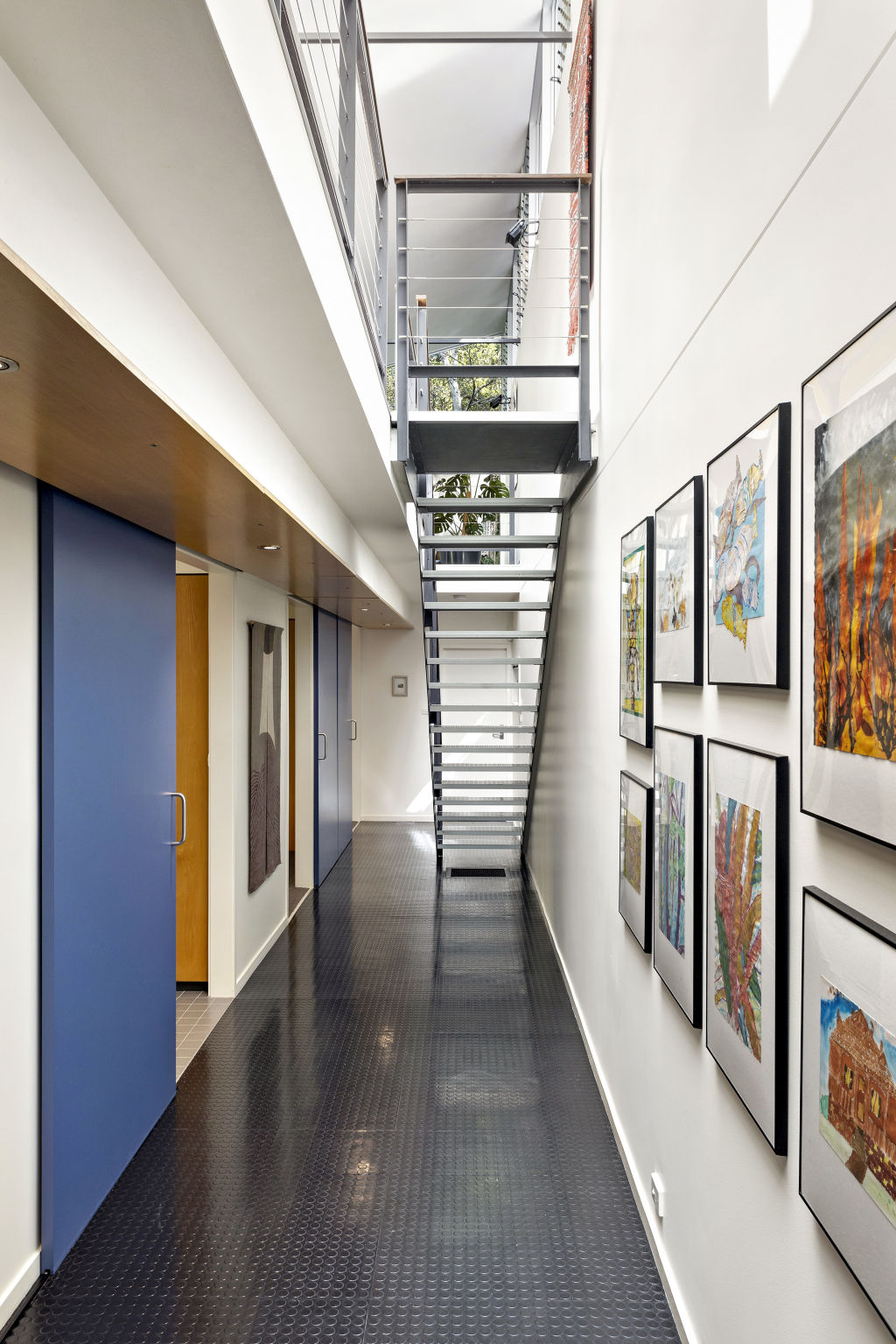 The open-tread staircase leads to the lower level which features a gallery-style hallway. Photo: Supplied