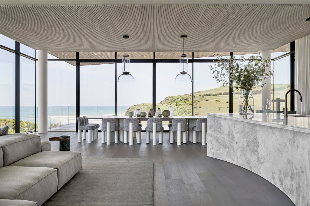 The light fittings over the dining table are glass so as not to interrupt the view. Photo: Peter Clarke