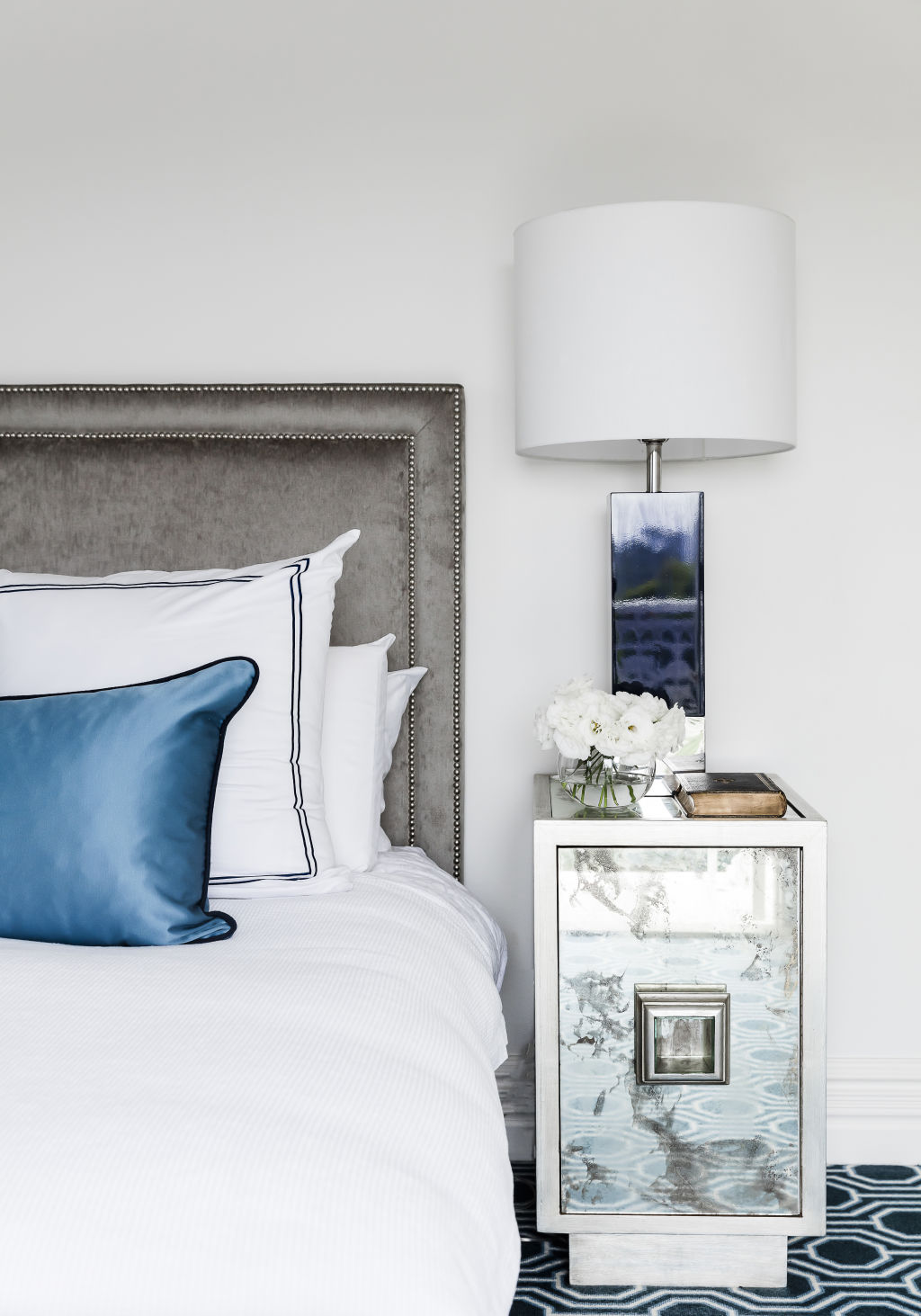 The serene main bedroom includes blue, navy and silver tones. Photo: Maree Homer