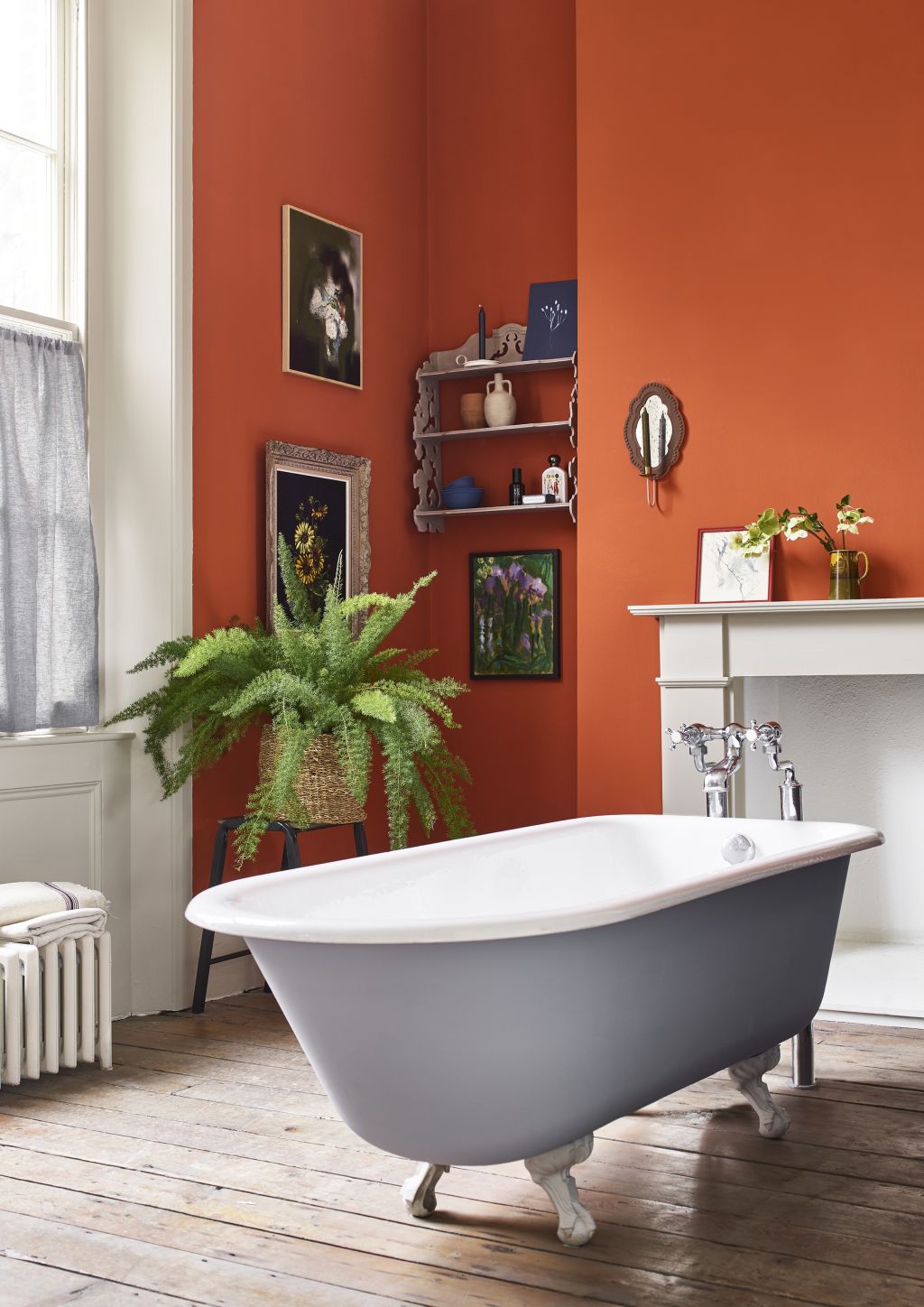 In this bathroom, Annie Sloan has opted for a warm terracotta wall paint and chalk paint in Louis Blue for the bath. Photo: Supplied