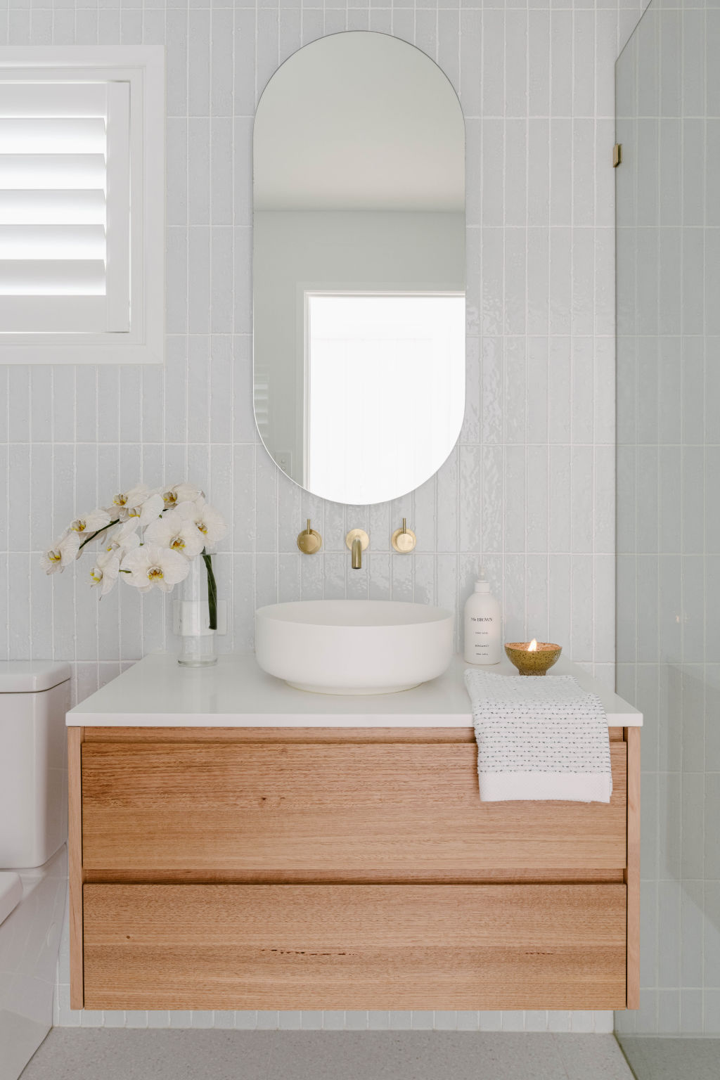 The bathroom features handmade “kit-kat” tiles, a custom vanity and brushed brass tapware. Photo: Hannah Puechmarin