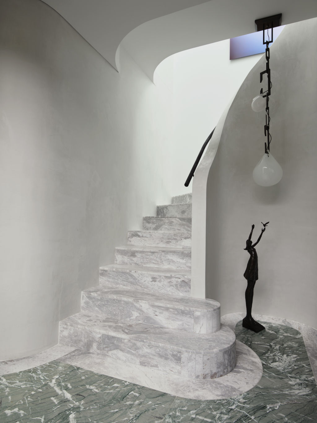 The curved Elba stone staircase makes a stunning first impression. Styling: Claire Del Mar. Photo: Anson Smart