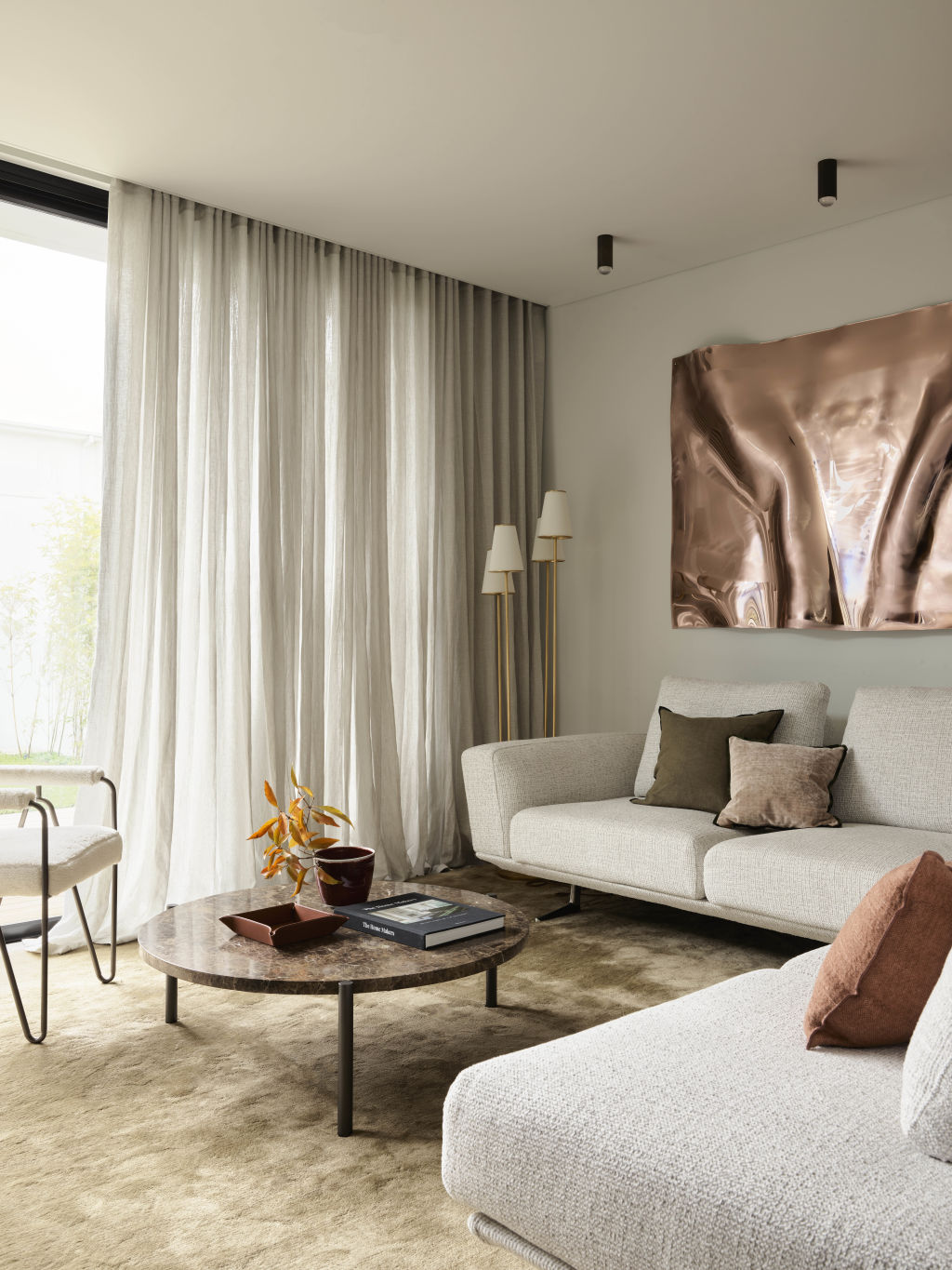 The living room features a brass artwork by local artist Anya Pesce. Styling: Claire Del Mar. Photo: Anson Smart