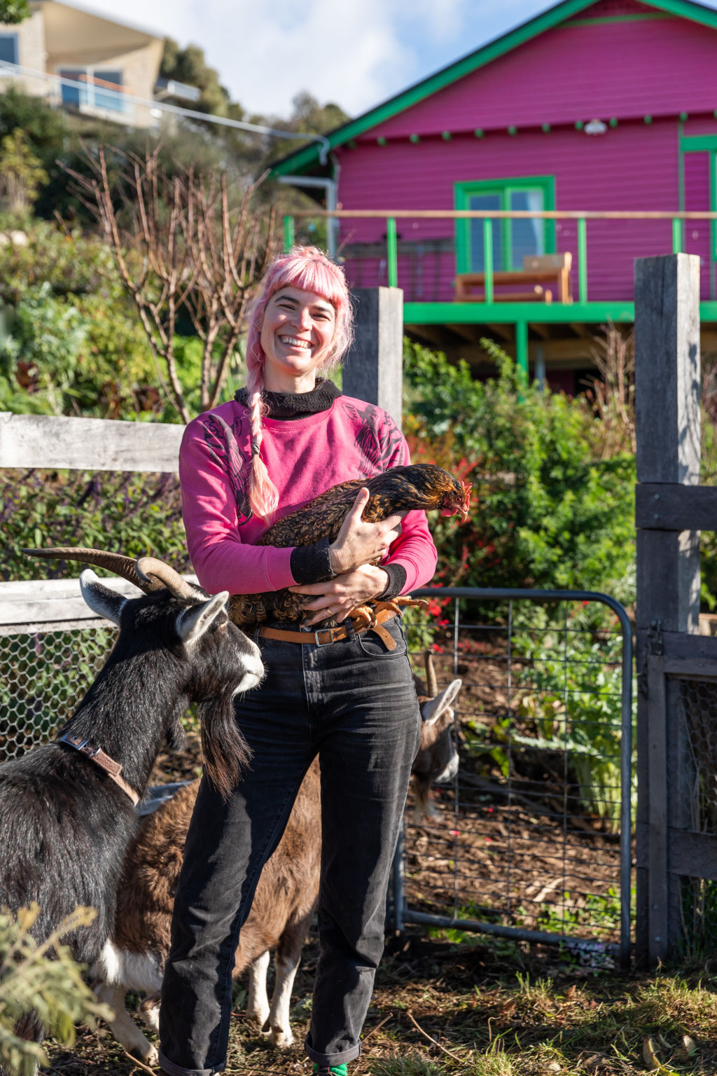 Hannah tends to the resident chickens and goats on the 3000-square-metre South Hobart property. Photo: NATASHA MULHALL