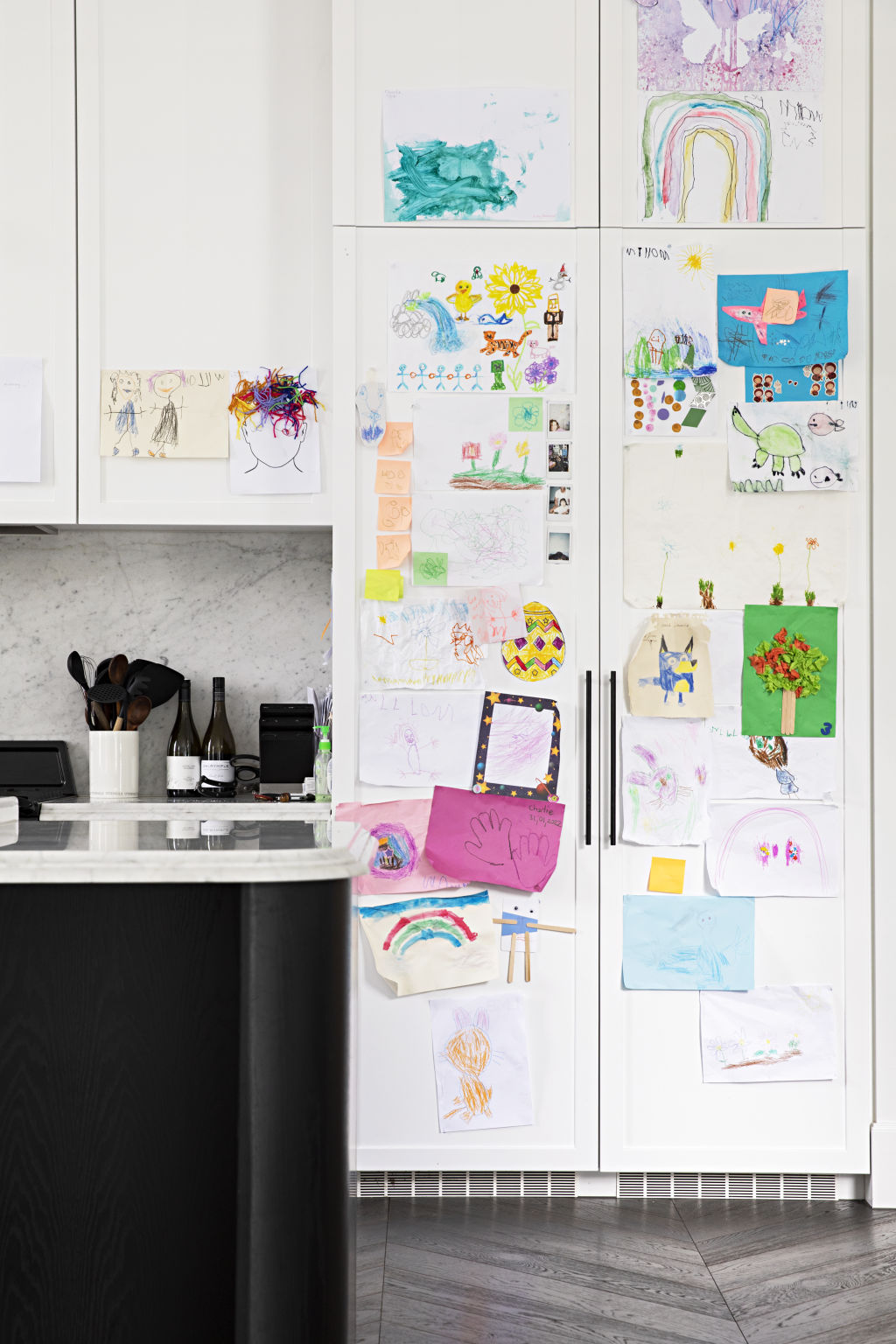 Artwork throughout the home was bought from Cool Hunter and Fenton and Fenton, but it's the kids' artwork that takes pride of place in the kitchen. Photo: Natalie Jeffcott