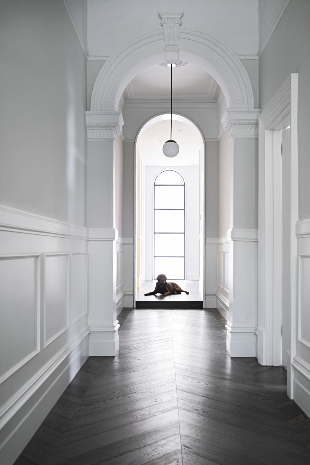 The five-bedroom, five-bathroom home is completed with dark parquetry flooring, big arches for an art deco nod, and an abundance of light. Photo: Natalie Jeffcott