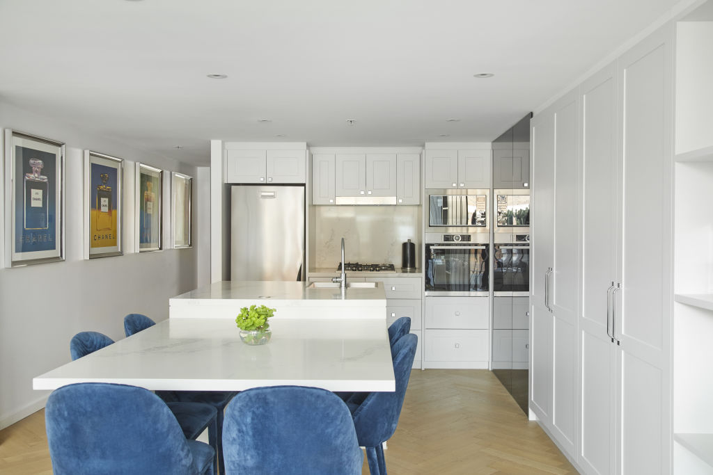 The Chanel prints and blue dining chairs adding a pop of colour to the kitchen space.  Photo: Nicky Ryan