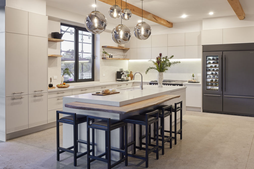 Timber ceiling beams and shelving add a touch of warmth in Rachel and Ryan's kitchen. Photo: Nine