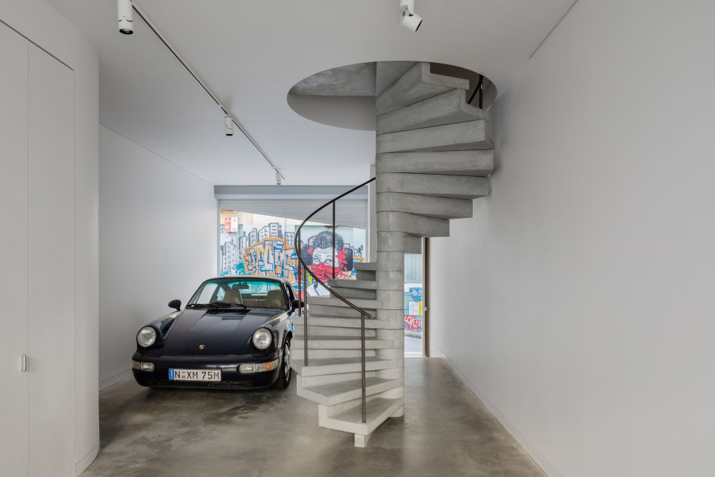 The concrete spiral staircase acts as a sculptural centrepiece to connect the three levels. Photo: Katherine Lu