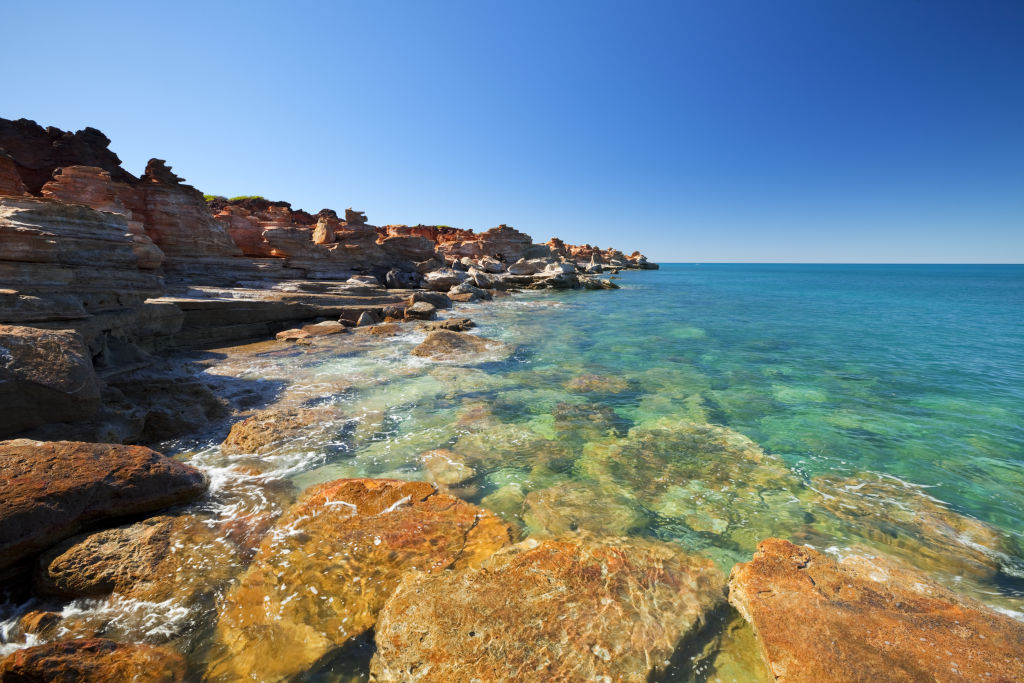 Red ochre cliffs tumble down into bright turquoise waters in Broome. Photo: Getty