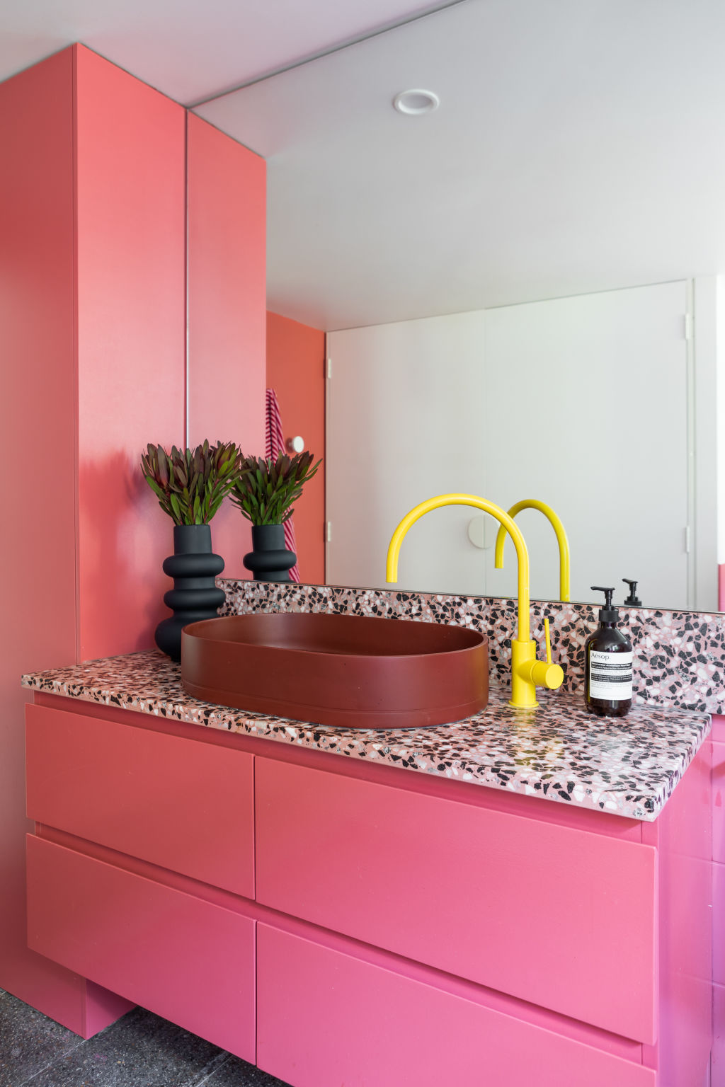Set around the original light-rose-toned bath and terrazzo floor, the bathroom feels like the glowing heart in the middle of the home.  Photo: Greg Briggs