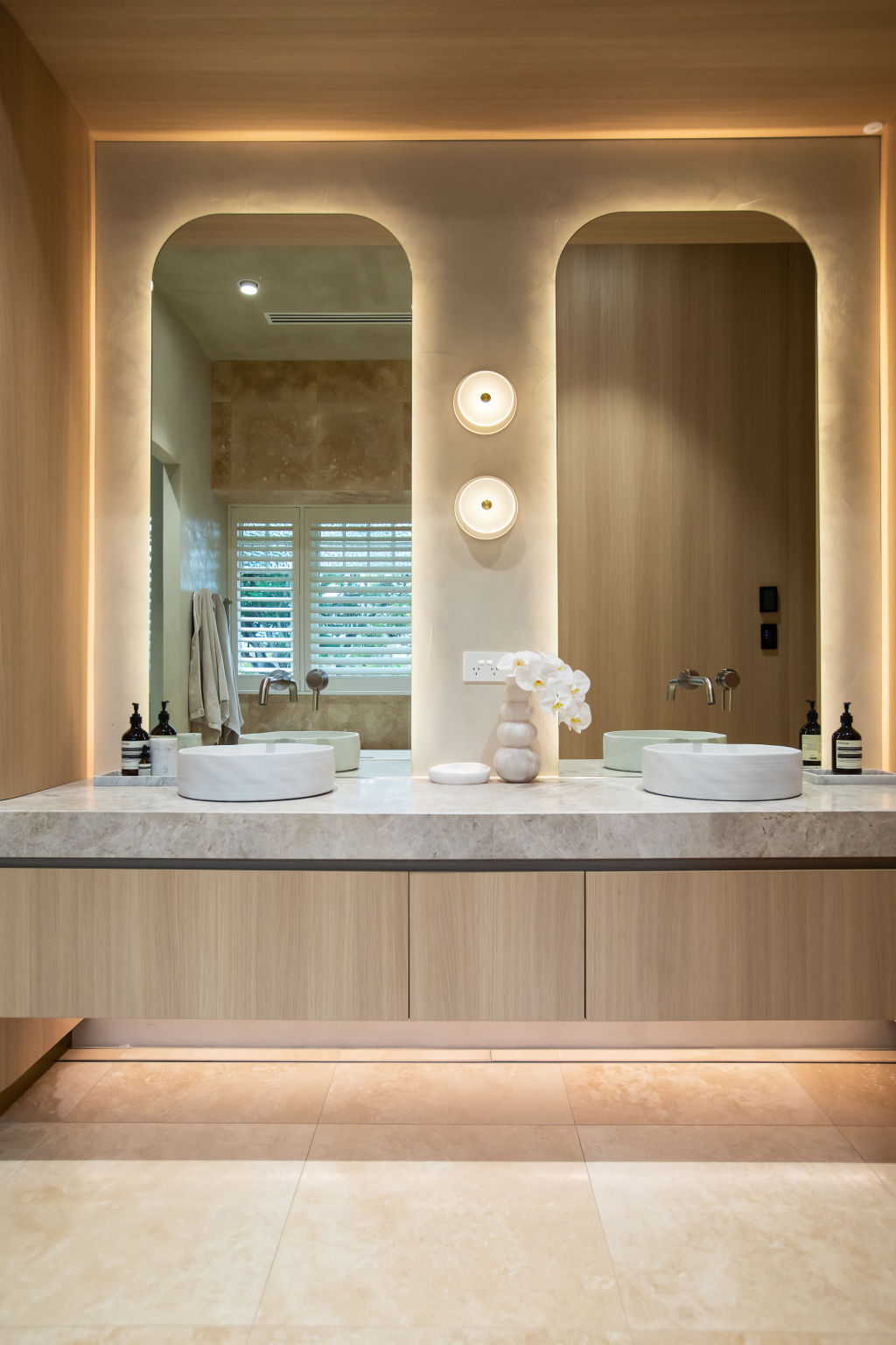 The en suite featuring Soktas hand-blown lighting, fluted glass and steel doors, and circular concrete basins. Photo: JOSIE WITHERS