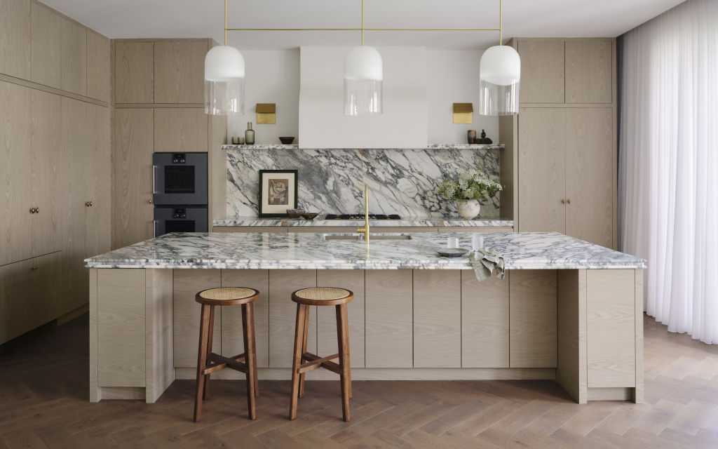 Brass folded wall sconces and a trio of glass Articolo pendants light the kitchen. Photo: Dave Wheeler