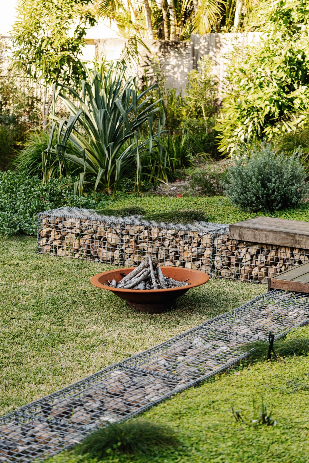 An outdoor fire pit is surrounded by gabion walls filled with Mary River stones. Photo: Marnie Hawson