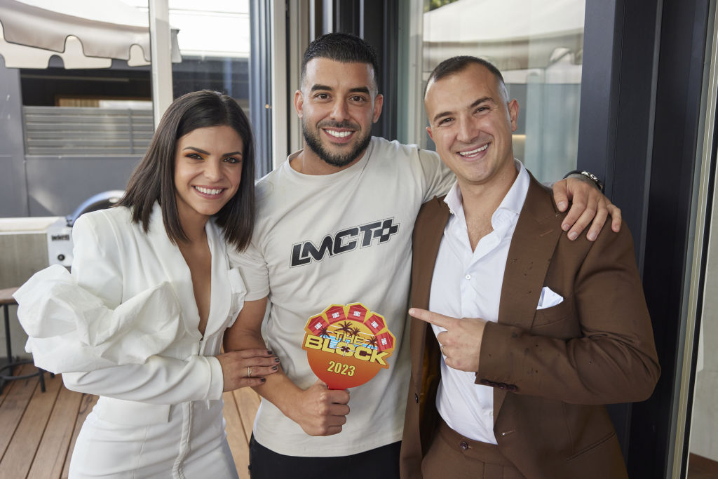 Winners are grinners - Steph and Gian smile alongside the man who made them a millionaire. Photo: Nine