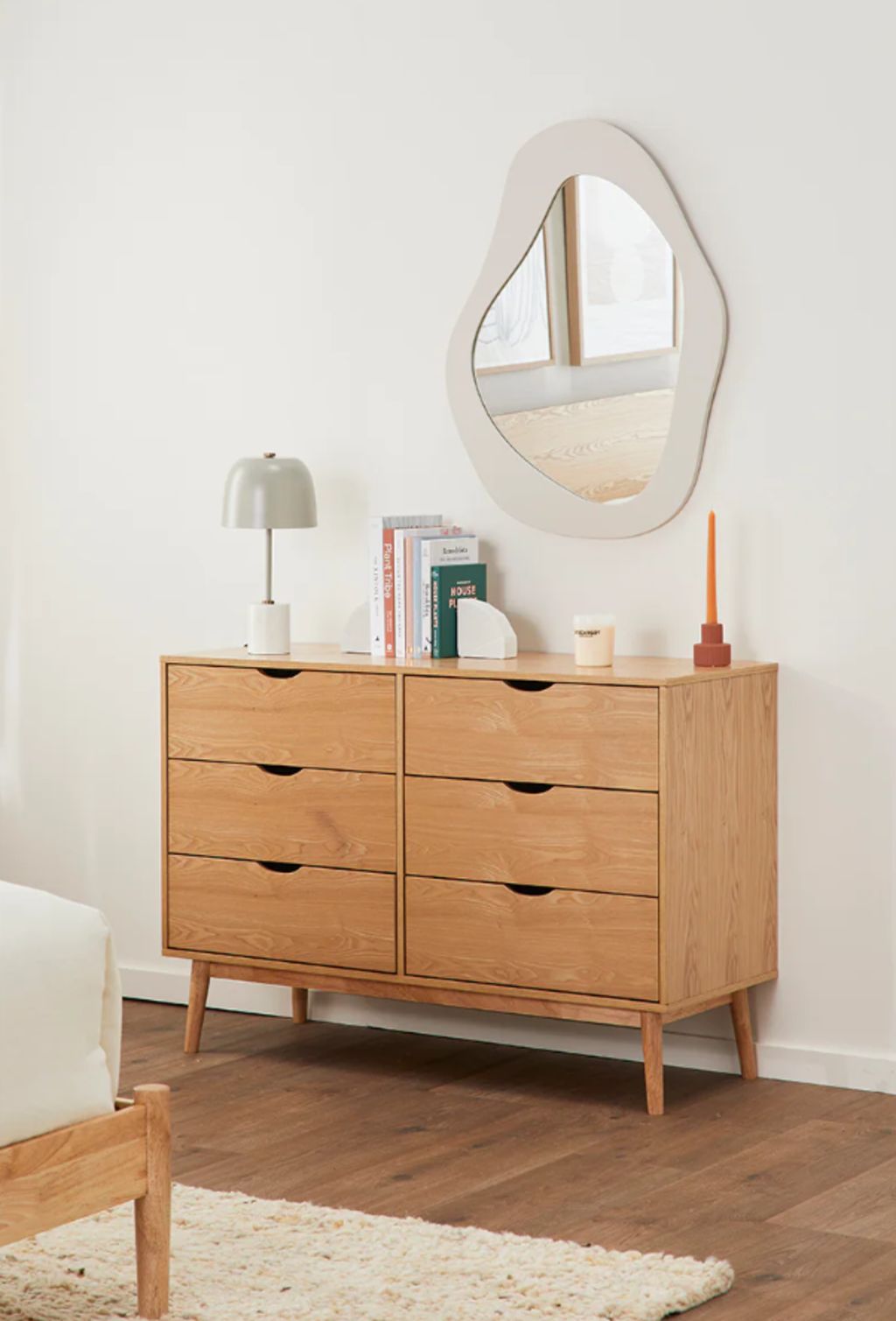 Asymmetrical pieces break up clean lines and help to soften a space. Aura mirror from Life Interiors. Photo: Supplied