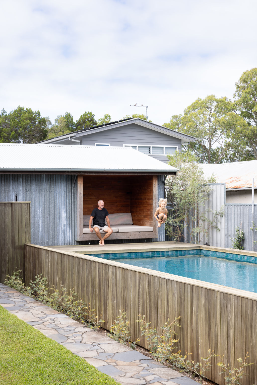 The deck leads out to a solar-heated pool bookended by a double garage. Photo: Louise Roche - The Design Villa