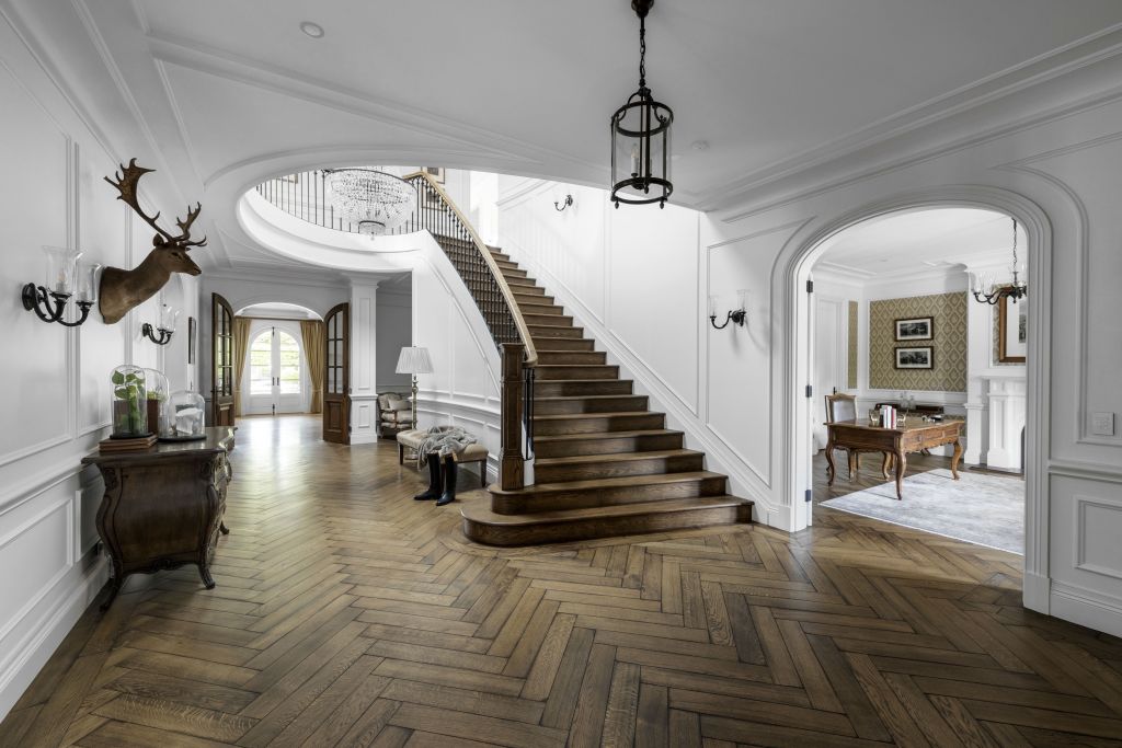 A grand staircase and crystal chandelier form and impressive entryway. Photo: Supplied