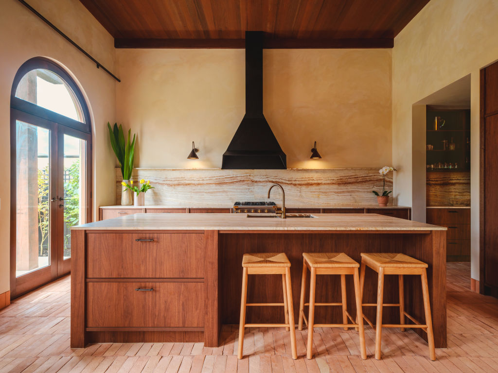 European oak joinery, tobacco-toned travertine benches make for a memorable kitchen. Photo: Victor Vieaux