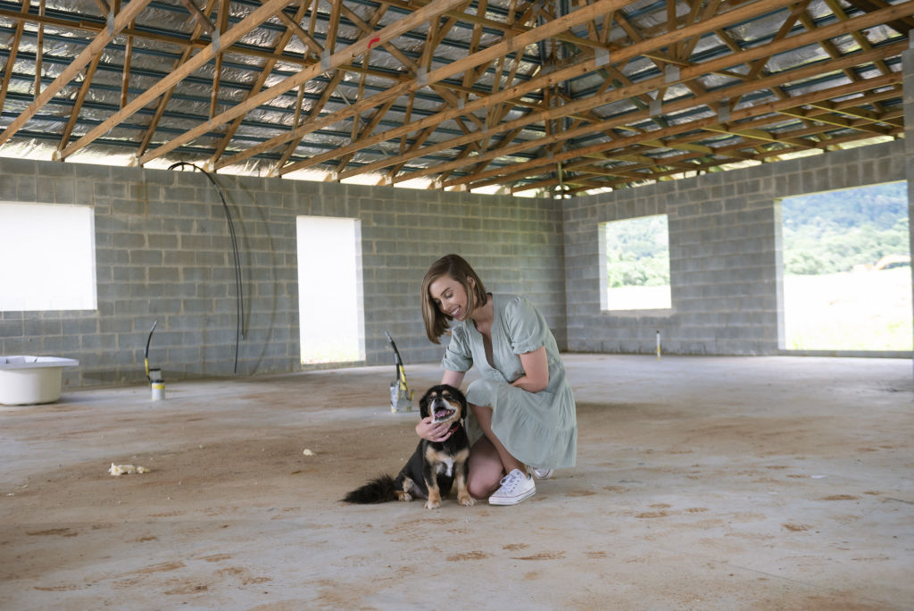 Rachel Synott with her dog Sunny in the house she is building. Photo: Veronica Sagredo