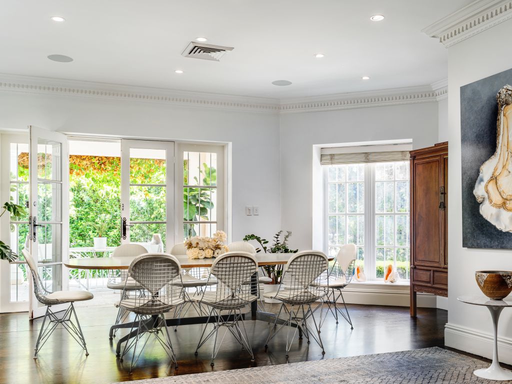 A green-walled al fresco zone connects to the elegant sitting room. Photo: Supplied