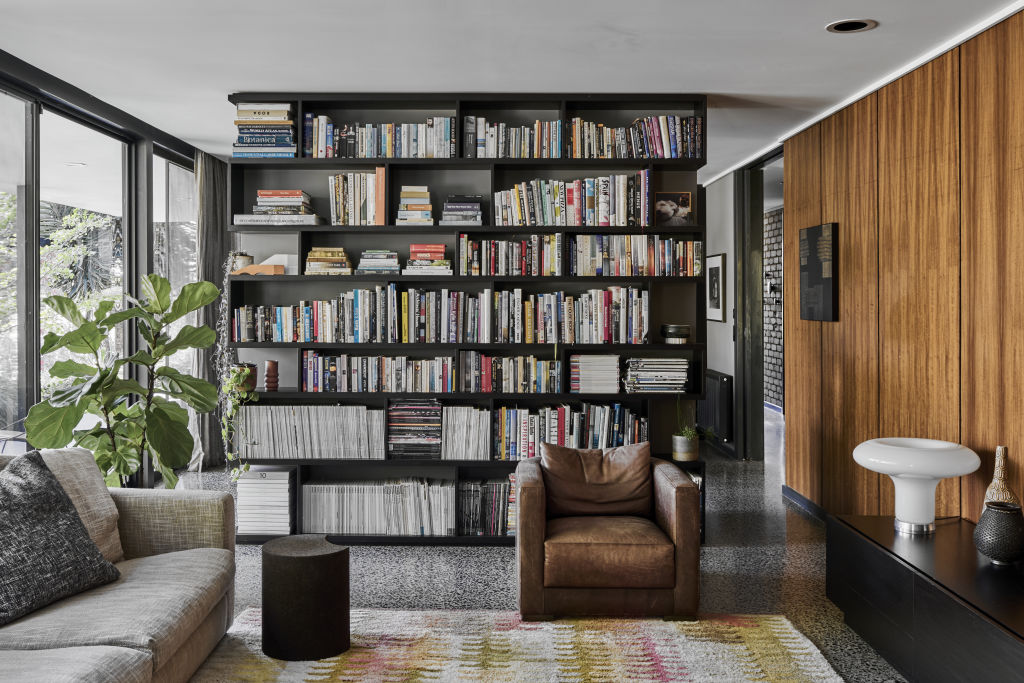 A ceiling-high bookcase separates the living and dining areas. Photo: Supplied