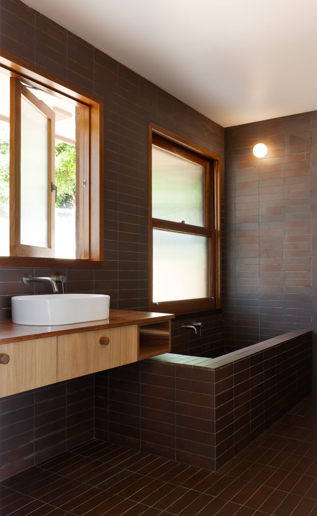 The architects drew inspiration from Taninaka's Japanese heritage, with timber throughout and Japanese tiles adding a spa-like feel in the bathrooms. Photo: Louise Roche