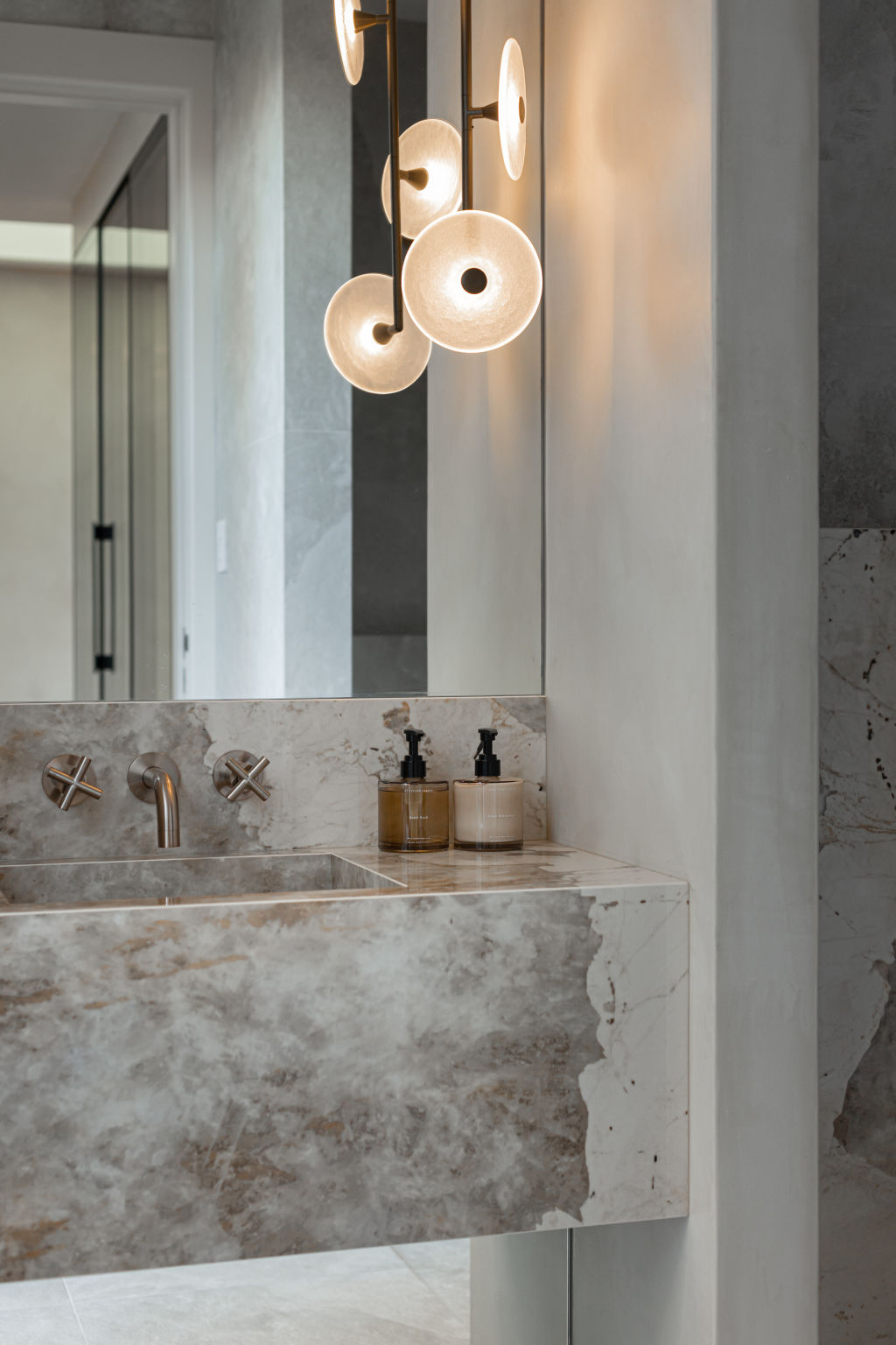 A floor-to-ceiling mirror gives the illusion that the integrated basin is floating. Photo: Grace Picot