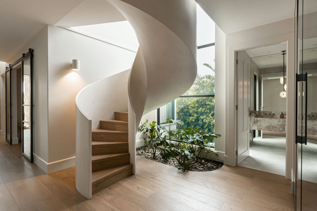 Both homes feature a standout helical staircase. Photo: Grace Picot