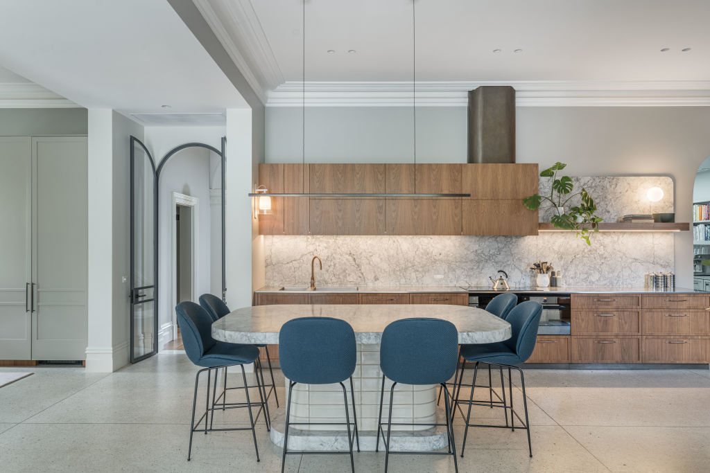 The kitchen features walnut cabinetry and a marble splashback.