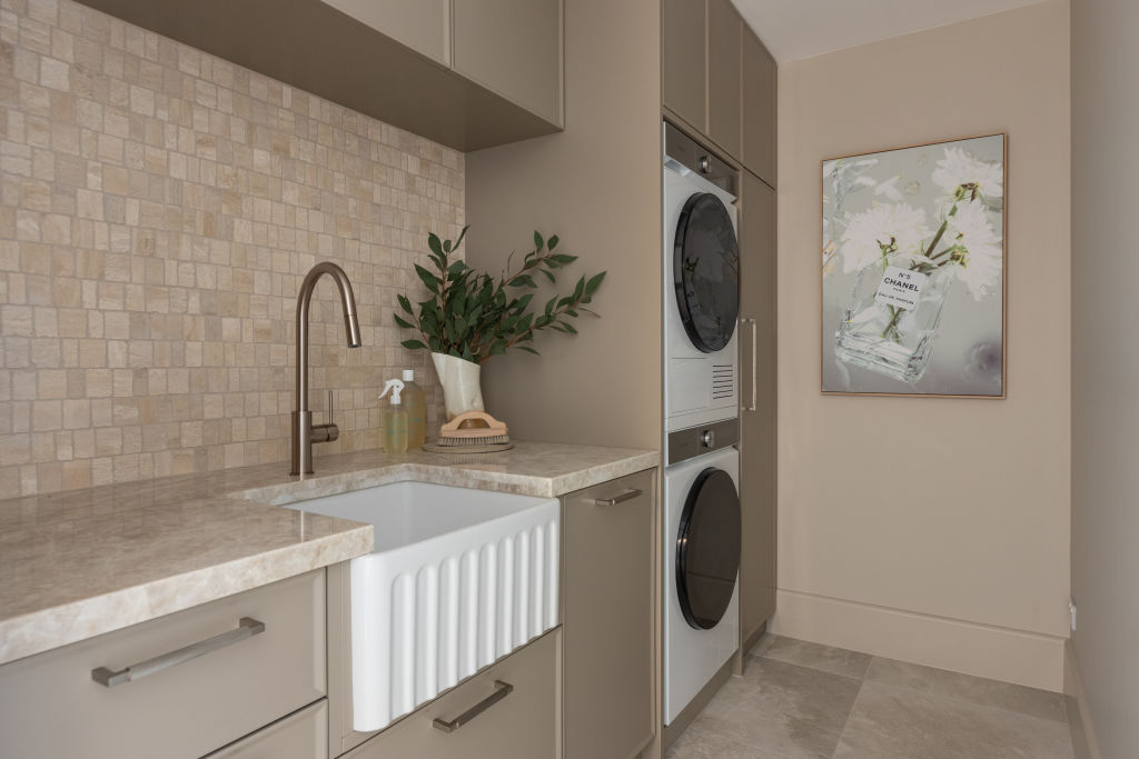 House One's laundry uses the same champagne tapware as the bathrooms throughout the home. Photo: Grace Picot