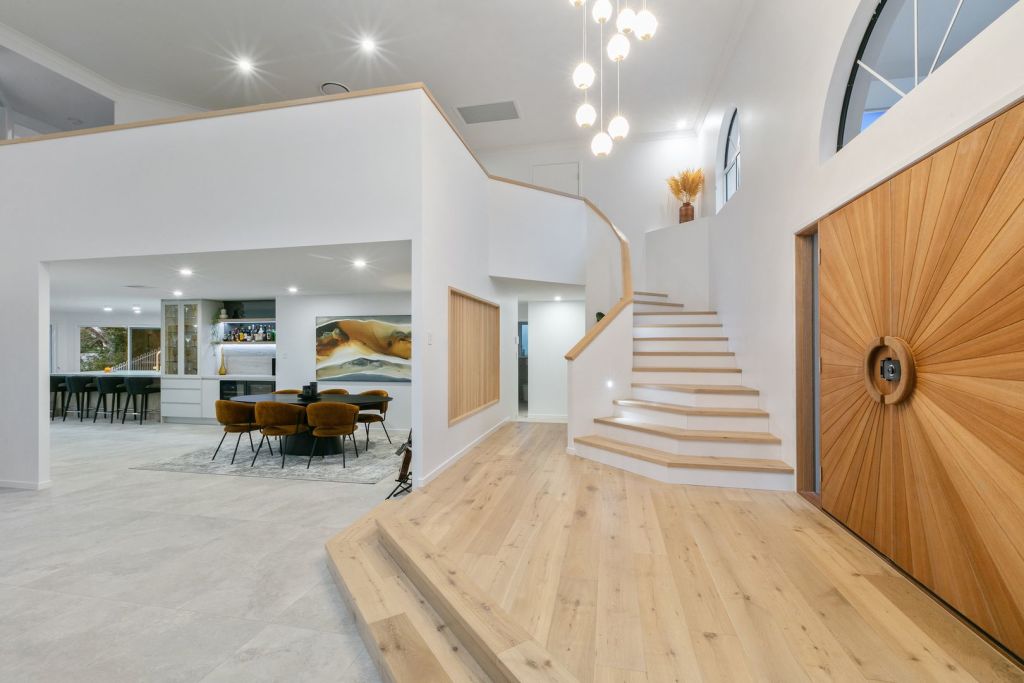 A soaring atrium and chandelier at the entry sets a glam tone. Photo: Queensland Sotheby's International Realty