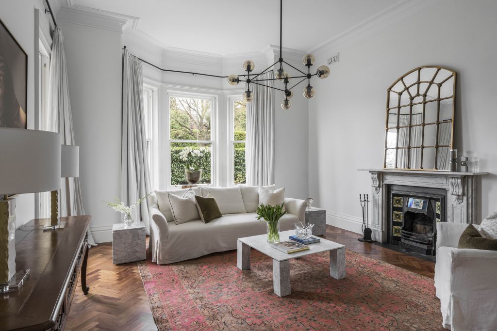 Parquetry floors roll across the foyer into the fine, front-facing living room.