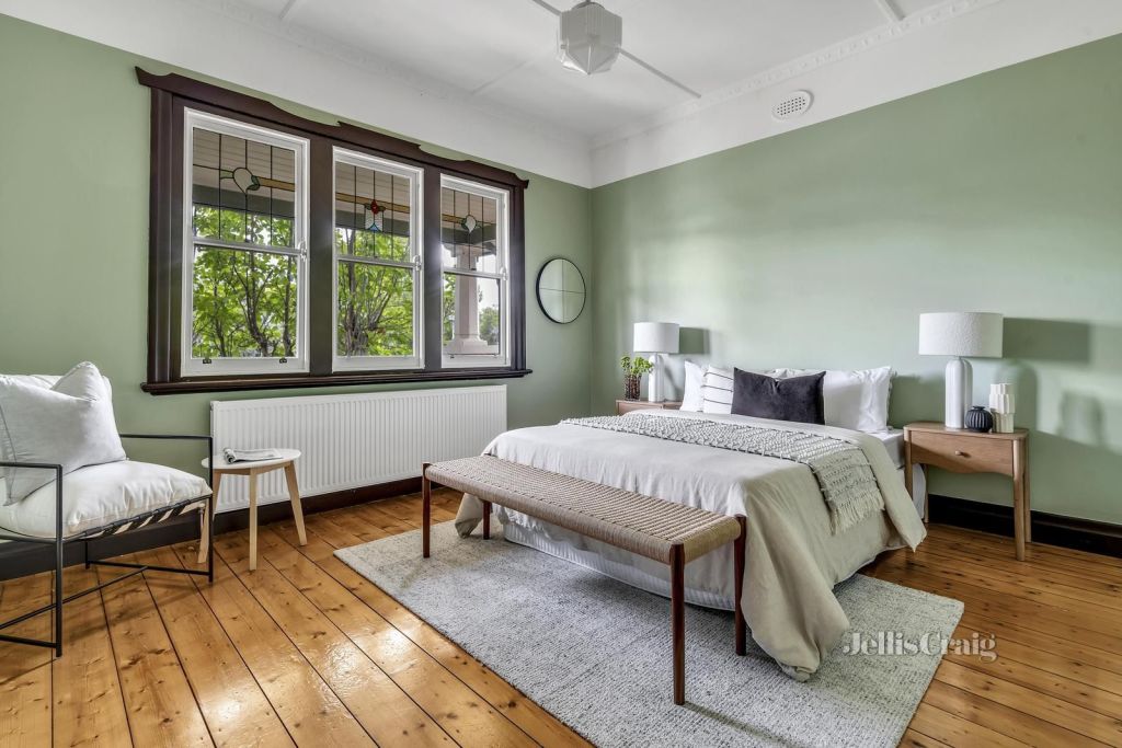 The bedroom has sage green walls and dark timber window frames. Photo: Jellis Craig Brunswick