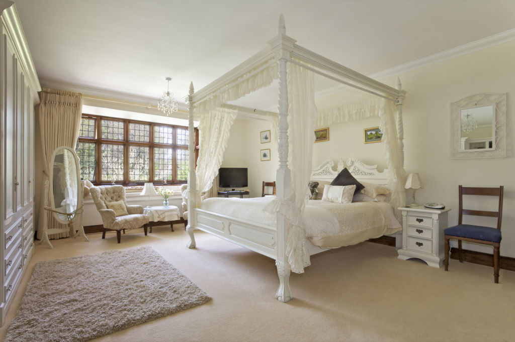 A canopied four-poster bed adds a touch of luxury. Photo: iStock / phototropic