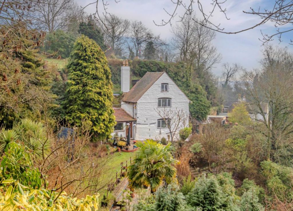 Rock cottage surrounded by bushland.